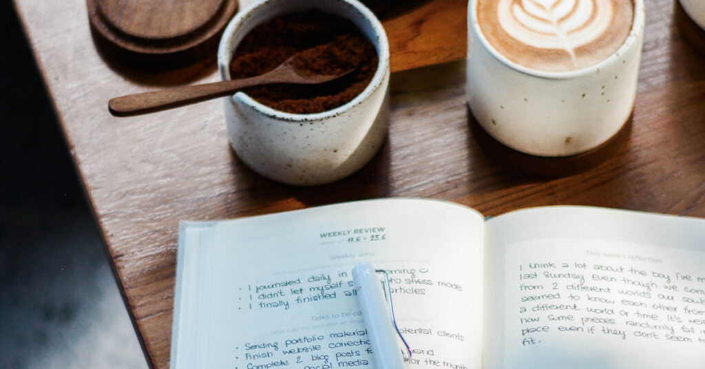 Open journal and mug of coffee