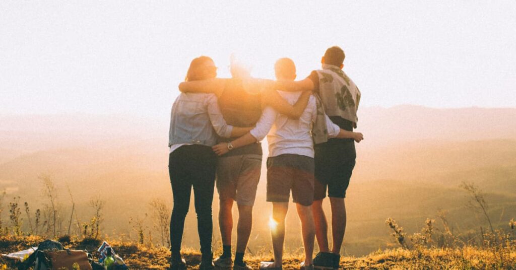 Group of people hugging at sunset