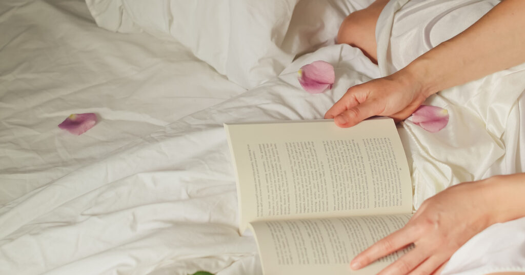 Open book in bed with petals surrounding it